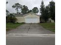 Traditional one-story home with an attached two car garage and a concrete driveway and a lawn at 27373 Sandrala Dr, Punta Gorda, FL 33955