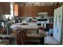 Functional kitchen with a breakfast bar, white appliances, wood cabinets, and lots of natural light at 27373 Sandrala Dr, Punta Gorda, FL 33955