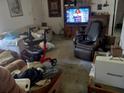 Cozy living room featuring multiple seating options, a large television, and personal decor throughout at 27373 Sandrala Dr, Punta Gorda, FL 33955