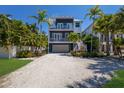 Stunning two-story house with a teal exterior and lush landscaping at 4105 4Th Ave, Holmes Beach, FL 34217