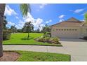 House exterior with a two-car garage and lush landscaping at 5107 Whispering Oaks Dr, North Port, FL 34287