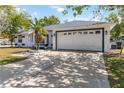 Front view of a single-story house with a white garage door and palm trees at 4907 21St E Way, Bradenton, FL 34203