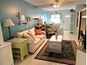 Bright living room with light beige couch, green armchair, and a coffee table at 5850 Welcome Rd # J6, Bradenton, FL 34207
