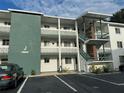 Exterior view of a two-story building with green accents, stairs, and parking at 5850 Welcome Rd # J6, Bradenton, FL 34207