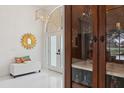 Elegant entryway with a white bench and a wooden bar cabinet at 3973 Boca Pointe Dr, Sarasota, FL 34238