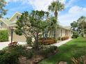 Landscaped exterior of a tan villa with a two-car garage at 4939 Lakescene Pl, Sarasota, FL 34243