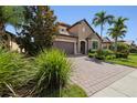 Two-story house with gray garage door and landscaping at 5828 Pomarine Ct, Sarasota, FL 34238