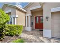Front entry with red double doors, paver walkway, and manicured landscaping at 5111 51St W Ln, Bradenton, FL 34210