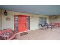 Covered porch with seating and red door at 2611 Sunnyside St, Sarasota, FL 34239