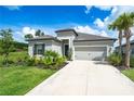 One-story home with gray exterior, landscaping, and a two-car garage at 9025 Tequila Sunrise Dr, Sarasota, FL 34241