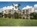 Condo building with palm trees and a pond in front at 5855 Midnight Pass Rd # 420, Sarasota, FL 34242