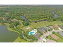 Aerial view of a community pool, lake, and winding river surrounded by lush greenery at 16916 Rosedown Gln, Parrish, FL 34219