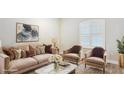 Bright living room with a large window, neutral color palette, and stylish staging at 16916 Rosedown Gln, Parrish, FL 34219