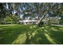 A charming ranch-style home nestled on a spacious lot with mature trees at 3556 E Forest Lake Dr, Sarasota, FL 34232