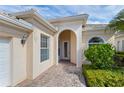 Inviting home exterior with a paved walkway, arched entryway, and lush landscaping at 13180 Ipolita St, Venice, FL 34293