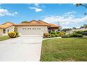 Front view of house showcasing a two-car garage and landscaping at 4995 Pepperwood Pl, Venice, FL 34293