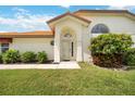 House entrance with lush landscaping and a welcoming front door at 4995 Pepperwood Pl, Venice, FL 34293
