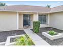 Front entry with a black door and walkway, surrounded by landscaping at 1410 67Th W St, Bradenton, FL 34209