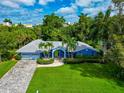 Inviting home with a spacious lawn, two-car garage, and mature palm trees enhancing its tropical appeal at 1389 Harbor Dr, Sarasota, FL 34239