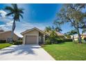 Single story home with attached garage and manicured lawn at 32 Inlets Blvd # 32, Nokomis, FL 34275