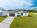 Modern home with dark brown garage door and paver driveway at 1094 Rotonda Cir, Rotonda West, FL 33947