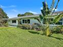 Ranch-style home with a neatly manicured lawn and tropical plants at 3510 Iroquois Ave, Sarasota, FL 34234