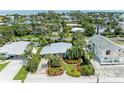 Aerial view of a charming home surrounded by lush landscaping and mature trees at 136 Crescent Dr, Anna Maria, FL 34216