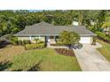 Single-story home with a gray roof, landscaped yard, and driveway at 1833 Sandalwood Dr, Sarasota, FL 34231