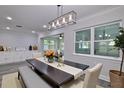 Elegant dining room with a modern light fixture, a large window, and a stylish table setting for gatherings at 2912 Pinecrest Way, Sarasota, FL 34239