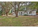 Charming home featuring an arched walkway and lush landscaping with mature trees on a well-maintained lawn at 2912 Pinecrest Way, Sarasota, FL 34239