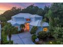 Beautiful home featuring a white roof, manicured landscaping, and a private driveway at 7620 Club Ln, Sarasota, FL 34238