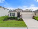 One-story home with light beige siding, stone accents, and a two-car garage at 12423 Nantahala Run, Parrish, FL 34219