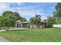Side view of a single-story house with a grassy yard and palm trees at 6106 45Th W St, Bradenton, FL 34210