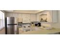 Small kitchen with white cabinets and stainless steel appliances at 400 Base E Ave # 229, Venice, FL 34285
