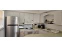 Small kitchen with white cabinets, stainless steel appliances, and light countertops at 400 Base E Ave # 229, Venice, FL 34285