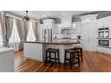 Spacious kitchen with white cabinetry, stainless steel appliances, an island with seating, and hardwood floors at 1332 3Rd W Ave, Bradenton, FL 34205