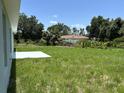 Expansive backyard featuring a patio and view of the neighboring houses surrounded by mature trees at 5018 Wagon Wheel Dr, North Port, FL 34291