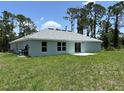 A view of the backyard of a single-story home showing the green lawn and the back of the house at 5018 Wagon Wheel Dr, North Port, FL 34291