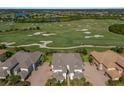 Stunning aerial view of property overlooking lush golf course and lake, set among luxurious homes at 7390 Divot Loop, Lakewood Ranch, FL 34202