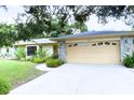 Charming home featuring a stone facade, mature trees, and a well-manicured lawn at 7607 9Th Avenue Nw Dr, Bradenton, FL 34209