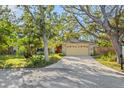 Charming home featuring a stone facade, mature trees, and a well-manicured lawn at 7607 9Th Avenue Nw Dr, Bradenton, FL 34209