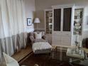 Living room with a cozy armchair, built-in shelving, and a glass coffee table at 5449 Downham Mdws, Sarasota, FL 34235