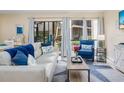Open concept living space with light-colored sofa and blue accent chairs at 6157 Midnight Pass Rd # A51, Sarasota, FL 34242