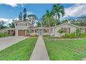 Front view of a charming two-story home with a landscaped yard at 303 48Th W St, Bradenton, FL 34209