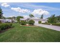 Landscaped yard with two-car garage and home exterior at 3653 Bonaventure Ct, Sarasota, FL 34243