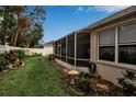 Landscaped backyard with a screened patio and a white fence at 11867 Hollyhock Dr, Lakewood Ranch, FL 34202