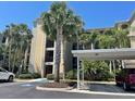 Condo building exterior with palm trees and covered parking at 7005 River Hammock Dr # 404, Bradenton, FL 34212