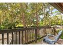 Relaxing balcony with wooded views and a comfortable chair at 1700 Glenhouse Dr # 406, Sarasota, FL 34231