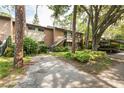 Exterior view of condo building, featuring a walkway, carport, and lush landscaping at 1700 Glenhouse Dr # 406, Sarasota, FL 34231