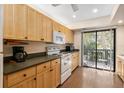Bright kitchen with light wood cabinets, modern appliances, and laminate flooring at 1700 Glenhouse Dr # 406, Sarasota, FL 34231